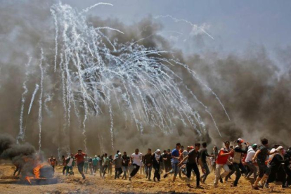 Los palestinos huyen de los gases lanzados por soldados israelís en Gaza.-AFP / MOHAMMED ABED