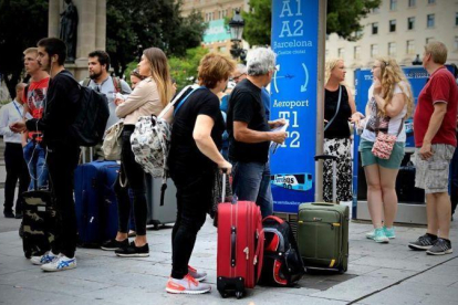 Turistas esperando el Aerobus en la Plaza Cataluña.-FERRAN NADEU