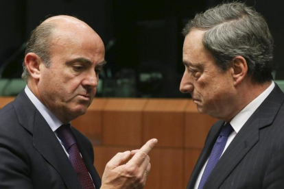 El ministro de Economía, Luis de Guindos, y el presidente del BCE, Mario Draghi, en una imagen de archivo.-JULIEN WARNAND / EFE