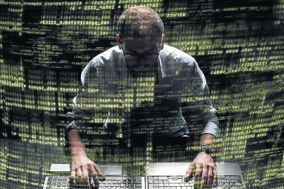 Silueta de un 'hacker' que utiliza un comando en la interfaz gráfica de usuario.-123RF