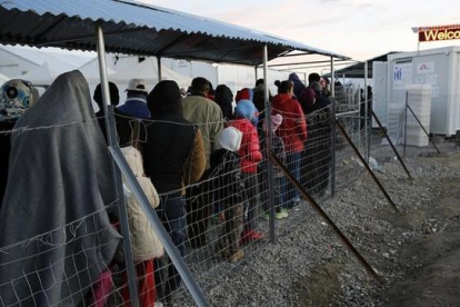 Refugiados y migrantes hacen cola durante la distribución de comida en un campamento cercano a Idomeni, en la frontera de Grecia con Macedonia, este jueves.-REUTERS / YANNIS BEHRAKIS