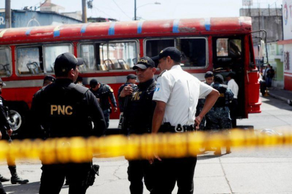 Policias expertos en explosivos trabajan en el lugar donde se produjo la detonacion de una granada en un autobus de pasajeros en Ciudad de Guatemala.-ESTEBAN BIBA / EFE