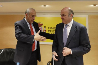 Ángel Gurría, secretario general de la OCDE, saluda a Luis de Guindos, ministro de Economía, el pasado marzo.-/ EFE / JAVIER LIZÓN