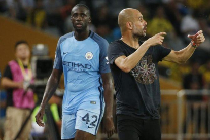 Touré Yaya y Guardiola, en un amistoso que jugó el City ante el Dortmund en China esta pretemporada.-BOBBY YIP