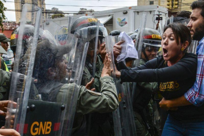 La diputada opositora Amelia Belisario se encara con la policía, en una protesta ante el Supremo, el jueves en Caracas.-AFP / JUAN BARRETO