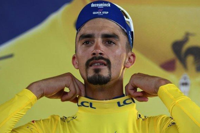 Julian Alaphilippe se ajusta el jersey amarillo en el podio de Toulouse.-ANNE-CHRISTINE POUJOULAT / AFP