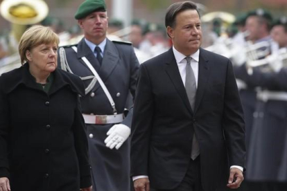 Merkel (izq) y el presidente de Panamá, Juan Carlos Varela, pasan revista a la guardia de honor antes de reunirse en la cancillería, en Berlín, este martes.-AP / MARKUS SCHREIBER