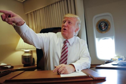 Trump señala a miembros de la prensa, sentado en su despacho del Air Force One, el 26 de enero.-AP / PABLO MARTINEZ MONSIVAIS