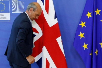 Un funcionario coloca las banderas de la UE y el Reino Unido al inicio de las negociaciones del brexit, el 19 de junio, en Bruselas.-REUTERS / FRANÇOIS LENOIR