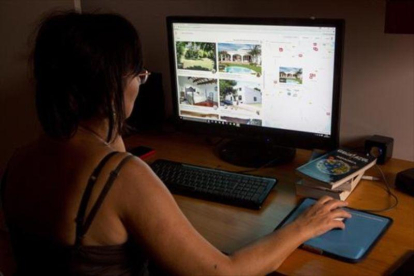 Una usuaria navega en la web especializada Airbnb.-FERRAN NADEU
