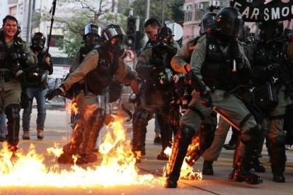 Agentes de policía en Hong Kong se preparan para una actuación entre llamas.-EFE / JEROME FAVRE