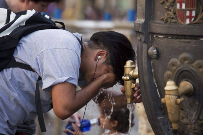 Un turista se refresca en la fuente de Canaletes durante una ola de calor.-Foto:   ARCHIVO / JOAN PUIG