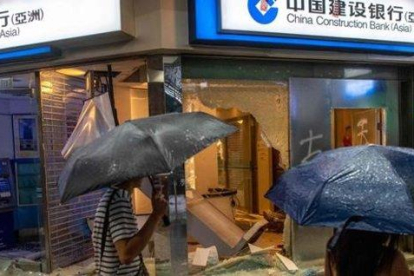 Vandalismo contra un banco de China en Hong Kong.-NICOLAS ASFOURI (AFP)