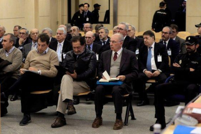El expresidente de Bankia Rodrigo Rato (derecha, en primera fila) junto al resto de acusados, durante la primera sesión del juicio.-EFE
