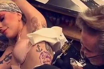 Lady Gaga, haciéndose el tatuaje de la cara de David Bowie.-