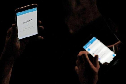 Usuarios consultan la ’app’ de Tsunami Democràtic, este jueves.-AFP / LLUÍS GENE