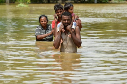 Una familia afectada por las inundaciones del ciclón Mora en la localidad de Kaduwela en Sri Lanka.-AFP