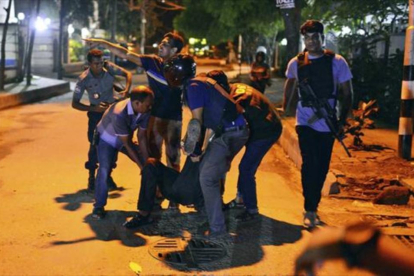 Un grupo de personas ayudan a un herido en el tiroteo en un restaurante de la zona diplomática de Dacca, capital de Bangladés.-AP