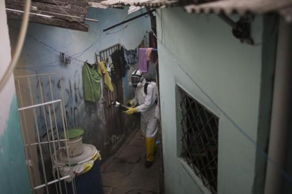 Un trabajador municipal fumiga para acabar con el virus de zika en un barrio de Recife (Brasil).-AP / FELIPE DANA