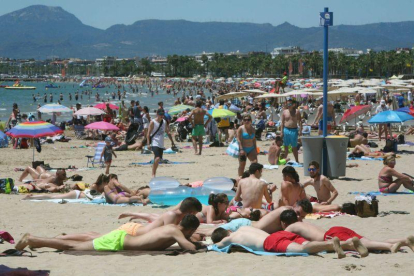 Cientos de personas se han acercado hoy a la playa de Levante de Salou, en Tarragona, en el primer fin de semana de las vacaciones de verano del mes de Julio.-EFE