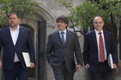 El president Carles Puigdemont, entre el vicepresidente Oriol Junqueras y el conseller Jordi Turull, en el Palau de la Generalitat-ALBERT BERTRAN
