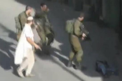 Un colono, con un pistola, tras abatir a un palestino en Hebrón.-