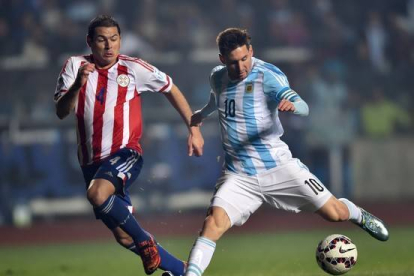 El jugador argentino, Lionel Messi, junto al defensa del Paraguay, Pablo Cesar Aguilar.-Foto: YURI CORTEZ / AFP
