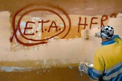 Un operario limpia una pintada a favor de ETA en Gernika.-EL PERIÓDICO