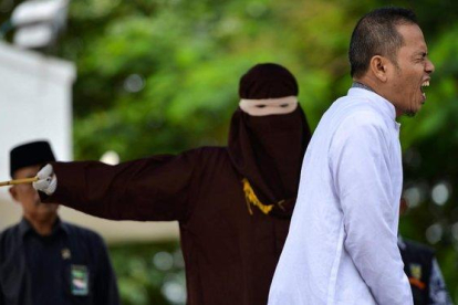 Mukhlis bin Muhammad se duele al encajar un latigazo de la policía de la sharia en la ciudad indonesia de Banda Aceh tras ser sorprendido cometiendo adulterio.-CHAIDEER MAHYUDDIN (AFP)