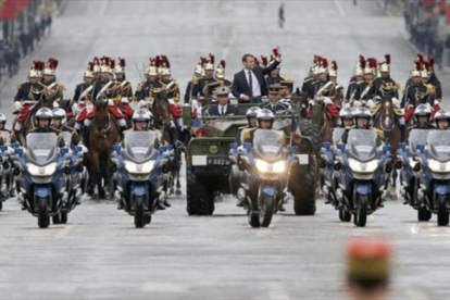 Macron saluda desde un vehículo militar a su paso por los Campos Elíseos.-MICHEL EULER