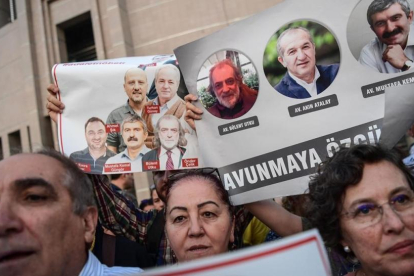 Un grupo de manifestantes muestran imágenes de periodistas del diario opositor Cumhuriyet, en una protesta en Estambul, el 28 de julio.-AFP / OZAN KOSE