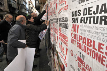 Pegada de carteles ayer de los sindicatos en El Collado en el que llamaron a la huelga general para el próximo 14 de noviembre. / VALENTÍN GUISANDE-