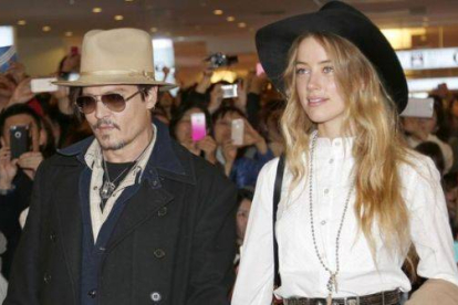 Johnny Depp y su novia, Amber Heard, este jueves en Tokio, a donde el actor ha viajado desde Australia para promocionar su última película, 'Mortdecai'.-Foto: AP / SHIZUO KAMBAYASHI