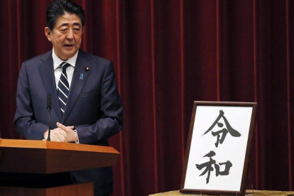 El primer ministro japonés, Shinzo Abe, muestra el nombre de la nueva era del emperador Naruhito.-AP / EUGENE HOSHIKO
