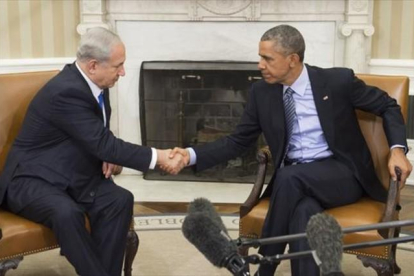 Obama y Netanyahu se saludan al inicio de su encuentro en el despacho Oval de la Casa Blanca, ayer.-AFP / SAUL LOEB