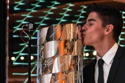 Marc Márquez besa el trofeo de plata maciza en el que están inscritos los nombres de todos los campeones de Moto GP.-ALEJANDRO CERESUELA