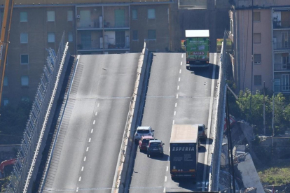 Un camión permanece al borde de la sección que continúa en pie del puente Morandi.-