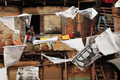 Vecinos del barrio de Shanty, Bangladesh, rodeados de publicidad electoral.-