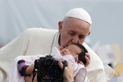 El Papa besa a un niño durante una misa en Nagasaki, este domingo.-EFE / EPA / KIMIMASA MAYAMA