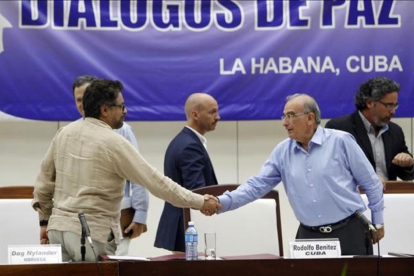 El comandante de las FARC y líder del equipo negociador de paz Luciano Marin 'Ivan Marquez' estrecha la mano del jefe negociador del Gobierno colombiano  Humberto de la Calle, el viernes.-ERNESTO MASTRASCUSA