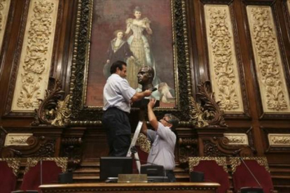 Dos trabajadores municipales retiran el busto del rey Juan Carlos I, en julio.-DANNY CAMINAL
