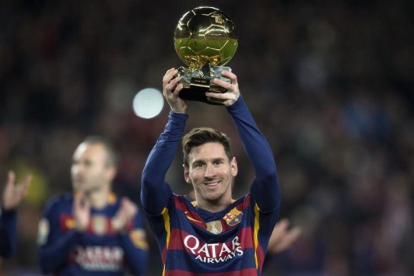 Messi enseña el último Balón de Oro que ganó (2015) en el Camp Nou.-JORDI COTRINA