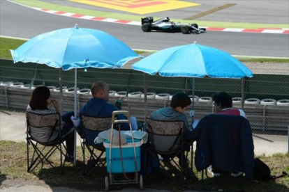 Una familia sigue la competición clasificatoria, ayer, en el circuito de Montmeló.-AFP