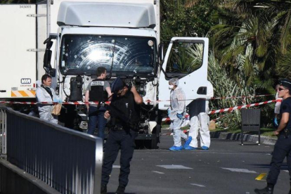 Forenses y policías buscan pruebas en el camión que arrolló a la multitud en Niza, el 14 de julio del 2016.-AFP / ANNE-CHRISTINE POUJOULAT