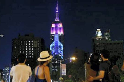 Ciudadanos y turistas se paraban ante el Empire State para inmortalizar el momento.  KENA BETANCUR / AFP