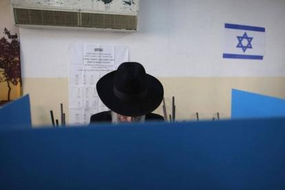 Un judío ultraortodoxo deposita su voto, este martes, en un colegio electoral en Jerusalén.-Foto: REUTERS / RONEN ZVULUN
