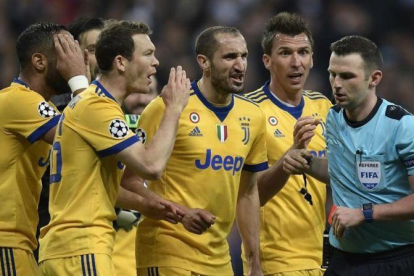 Los jugadores de la Juventus rodean al árbitro tras el polémico penalti.-AFP / OSCAR DEL POZO
