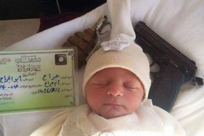 Fotografía de un bebé con un documento de identidad del Estado Islámico junto a una pistola y una granada.-Twitter