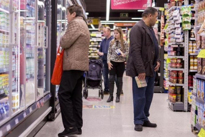 Un grupo de personas comprando en un supermercado.-FERRAN NADEU