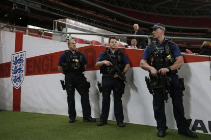 Policías británicos vigilan el interior del estadio londinense de Wembley.-AFP